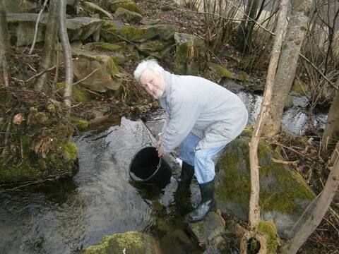 Bachbesatz 2013: Helfer setzt Jungfische aus dem Eimer in den Bach