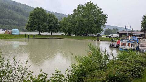 Die Donau bei Regenwetter, im Hintergrund bewaldete Hänge